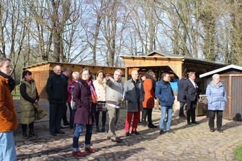 Gruppe von stehenden Personen im Freien mit zeigender Person