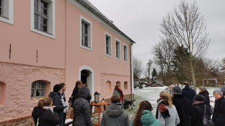 Bild der TeilnehmerInnen, die Steffi Dubrau vor einem Pücklerhaus in rosa zuhören